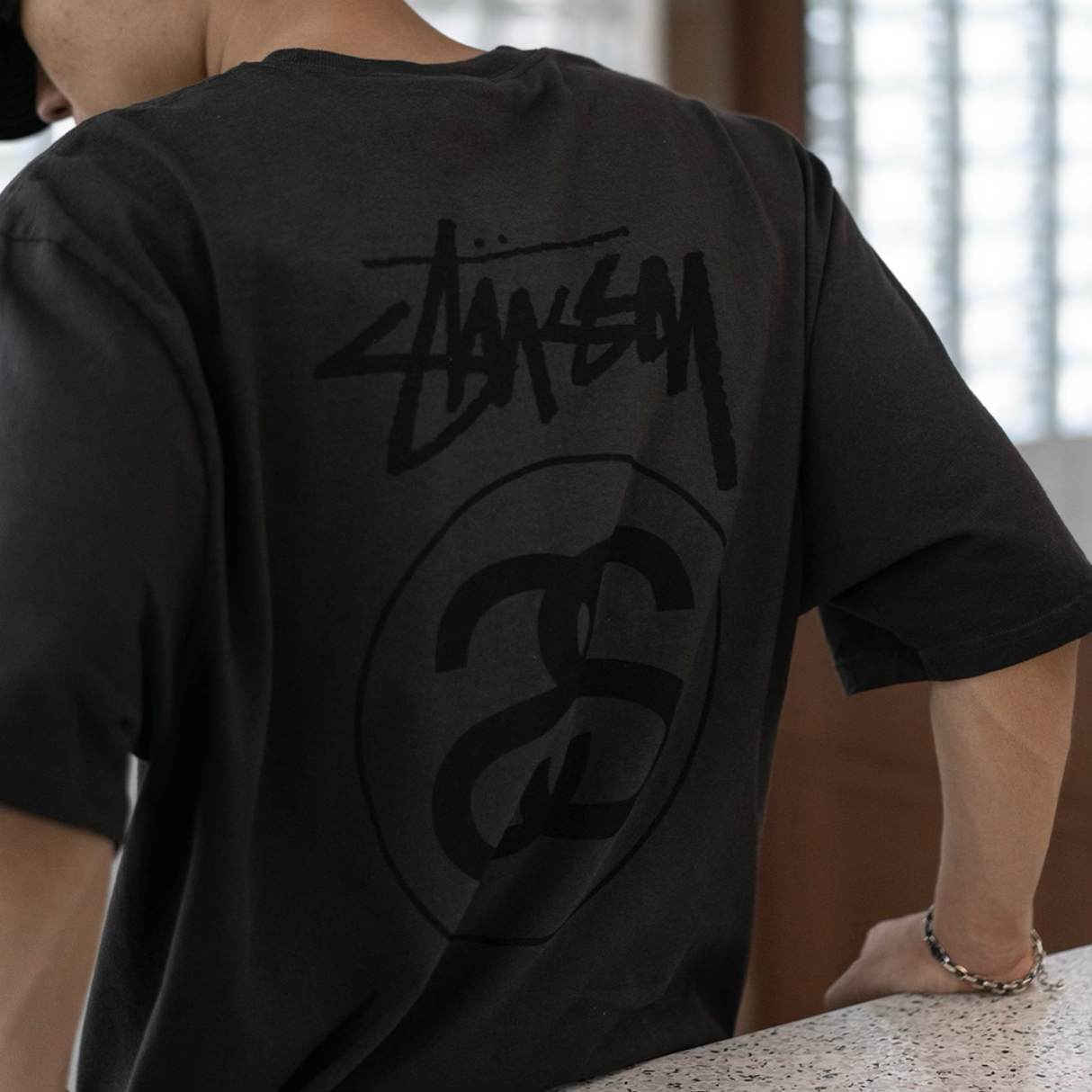 Faded black Stussy Stock Logo Tee featuring the brand's signature logo on the front, casual streetwear apparel.
