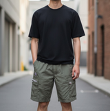 Olive AAPE By Bathing Ape badge cargo shorts with side pockets and logo patches, casual streetwear apparel for men.