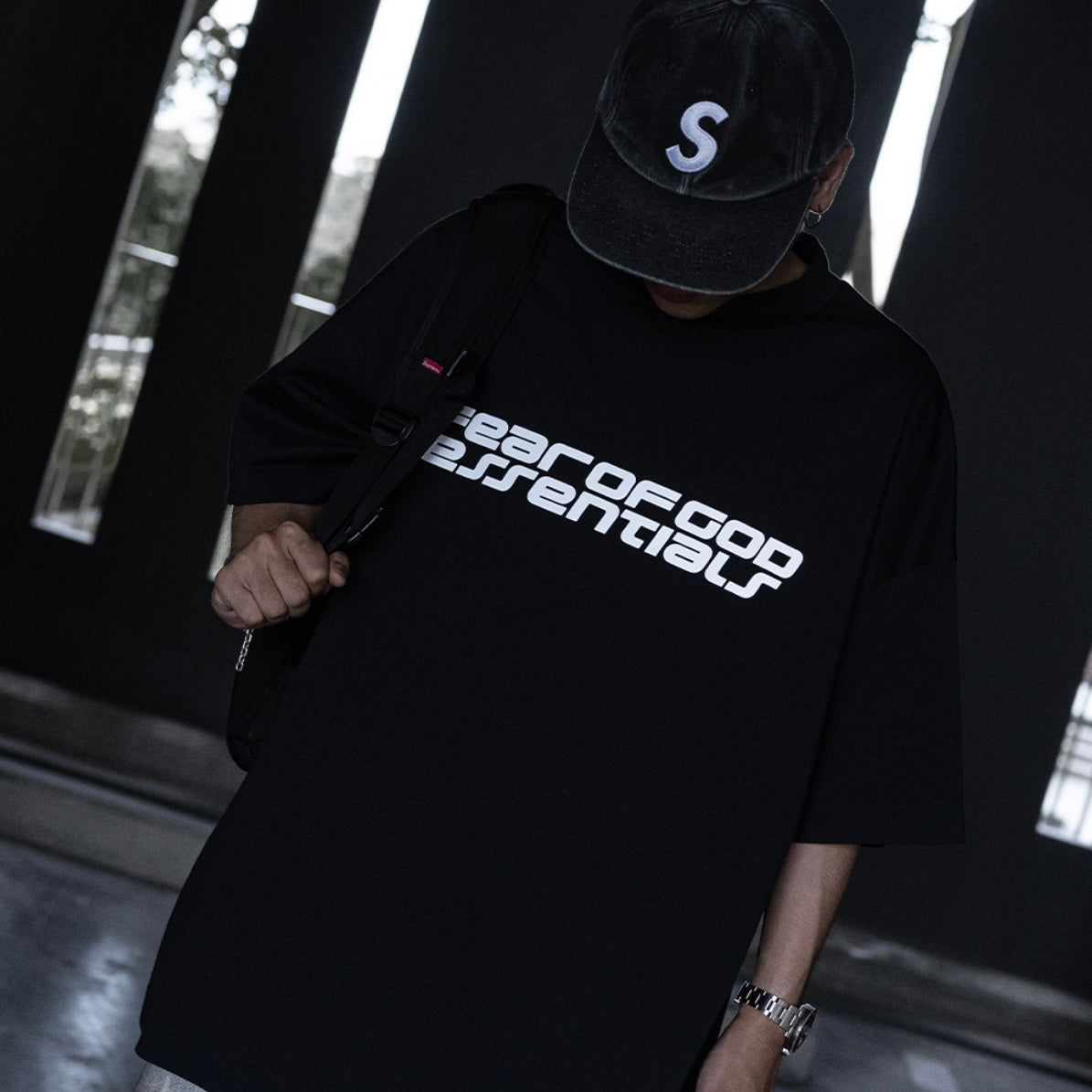 Black Fear of God Essentials Reflective Logo 90s T-shirt featuring a reflective logo print on the front.