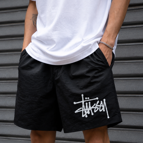 Black Stussy Basic Big Logo nylon shorts with a relaxed fit and bold logo print, perfect for casual summer wear.