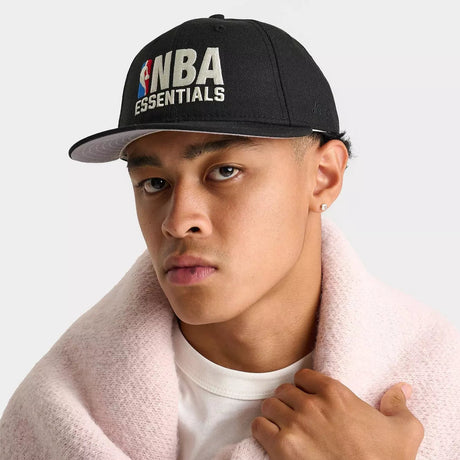 Fear of God Essentials NBA New Era 9FIFTY cap, adjustable headwear with team logo and iconic branding, front view.