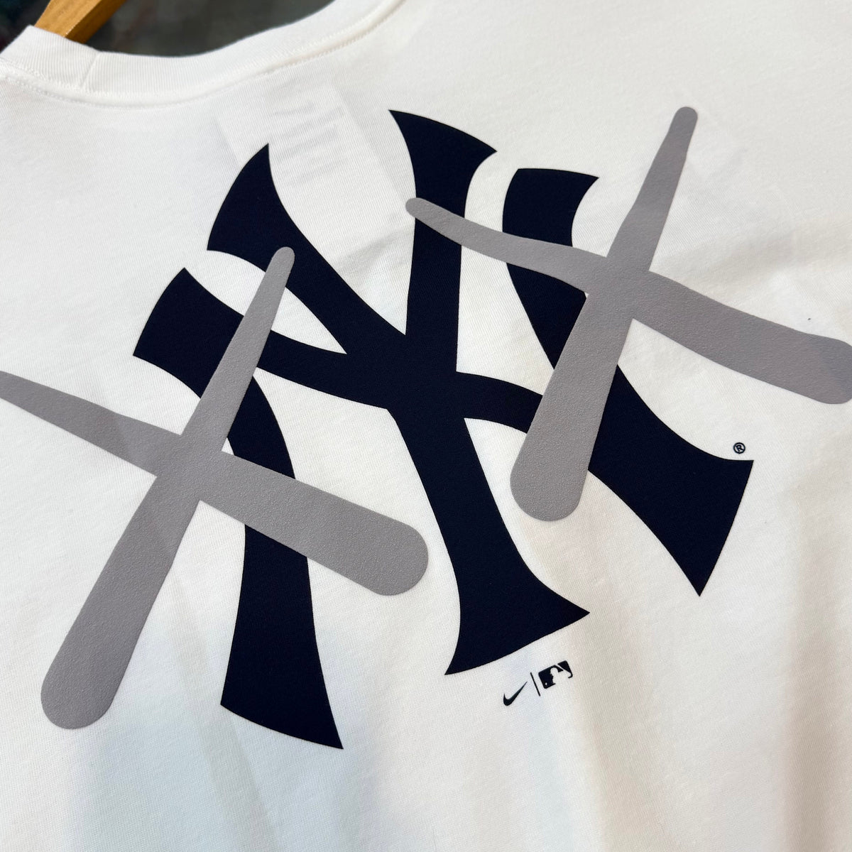 White KAWS X Nike MLB Elevated Max 90 T-shirt for men, featuring graphic design, casual apparel from HUMAN MADE.