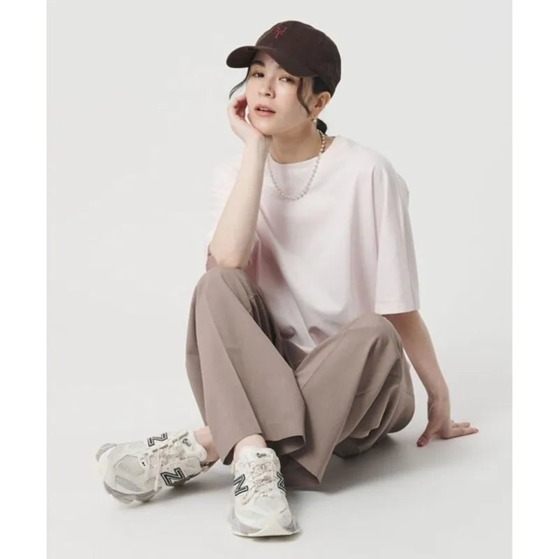 New Balance 9060 Mule sneakers in off-white and mauve with a chunky design and comfortable silhouette.