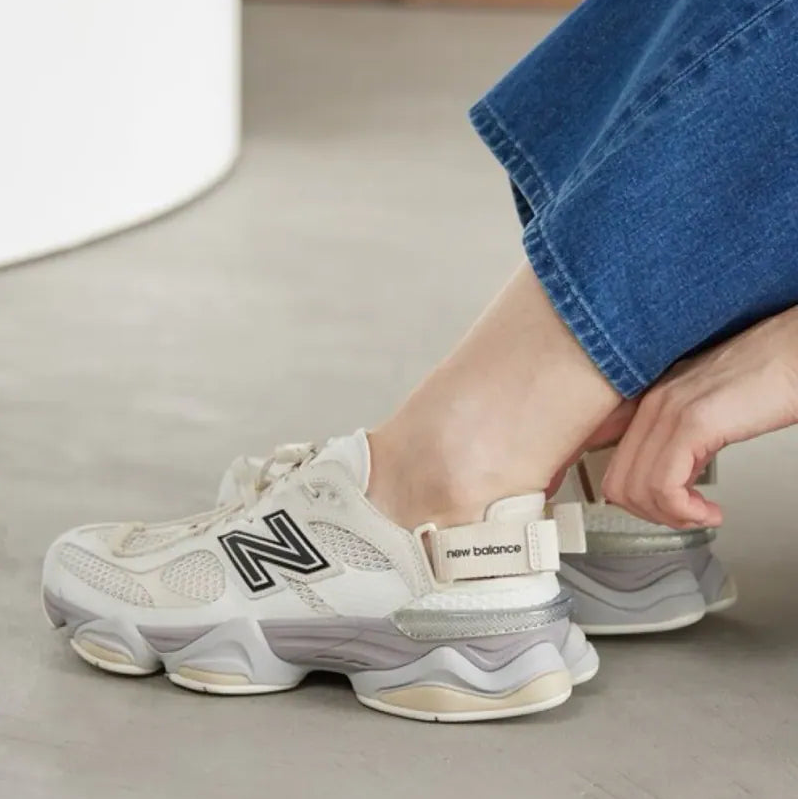 New Balance 9060 Mule sneakers in off-white and mauve with a sleek design and comfortable sole, displayed on a plain background.