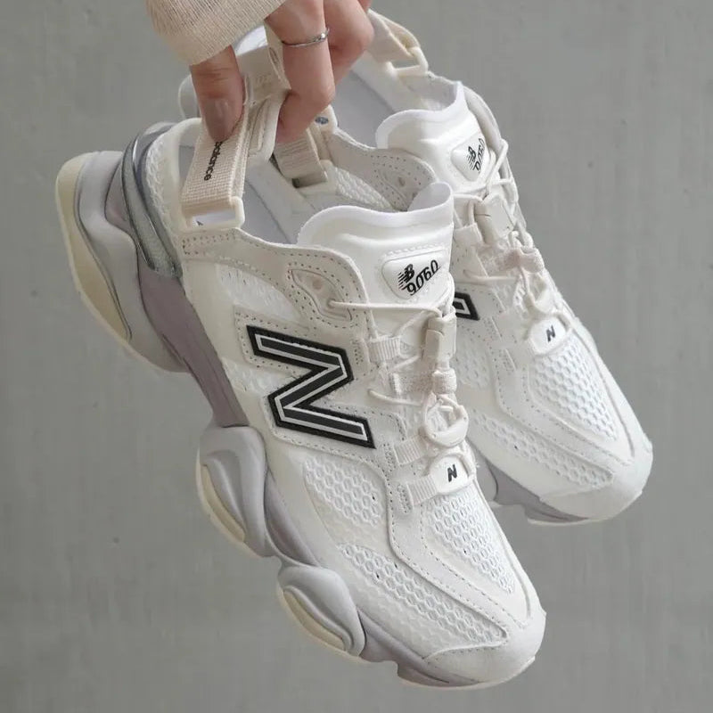 New Balance 9060 Mule sneakers in off-white and mauve with a sleek design and comfortable fit, detailed view of the footwear.