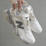 New Balance 9060 Mule sneakers in off-white and mauve with a sleek design and comfortable fit, detailed view of the footwear.