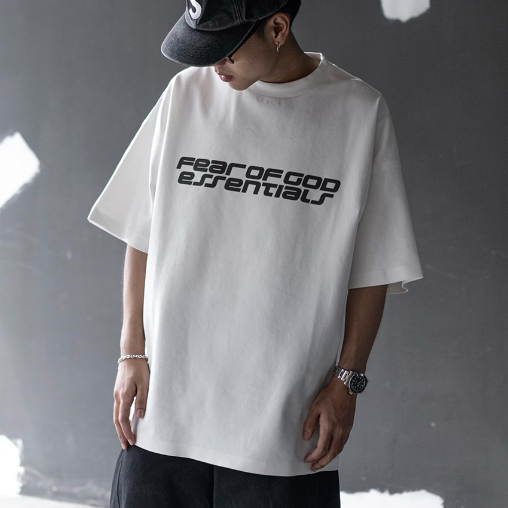 Fear of God Essentials reflective logo ponte 90s tee in ivory, featuring upgraded fabric and casual fit for everyday wear.