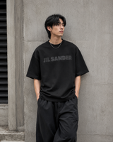 Black Jil Sander Signature Logo Tee shirt, casual apparel with prominent logo design, displayed on a plain background.