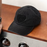 Black Human Made Heart Logo 6-panel cap featuring a front embroidered heart logo and adjustable strap, casual headwear for everyday style.