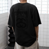 Stussy Stock Logo Tee in faded black, casual apparel featuring the iconic Stussy logo on the front.
