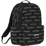 Supreme black reflective monogram logo backpack with silver logo, featuring adjustable shoulder straps and front zip pocket.