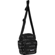 Supreme black reflective shoulder bag with silver monogram logo, featuring a sleek design and adjustable strap.