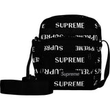 Supreme reflective black shoulder bag with silver monogram logo, featuring a sleek design and adjustable strap.
