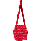 Supreme reflective monogram logo shoulder bag in red with silver logo, featuring a sleek design and adjustable shoulder strap.