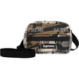 Supreme reflective mini shoulder bag with predator camo pattern and silver monogram logo, compact and stylish accessory.