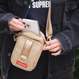 Supreme tan box logo sling bag with adjustable strap and sleek design, featuring the iconic Supreme logo on the front.