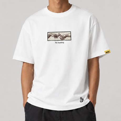 White FR2 embroidery smoking art tee featuring detailed smoking-themed design on the front, casual apparel by #FR2.