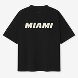 Fear of God Essentials NBA 90s Heavyweight Tee in black, featuring bold graphic design and comfortable heavyweight fabric.