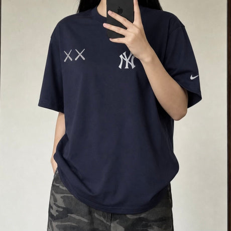 Navy MLB X KAWS X Nike New York Yankees tee shirt featuring graphic design, casual apparel by HUMAN MADE.