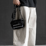 Black Human Made Military Mini Sling Bag with adjustable strap, compact design, and multiple compartments for everyday essentials.