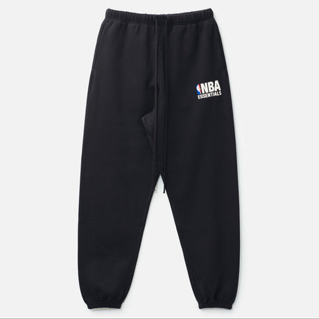 Black Fear of God Essentials NBA sweatpants featuring branded logo, relaxed fit, comfortable fabric, and athletic style.