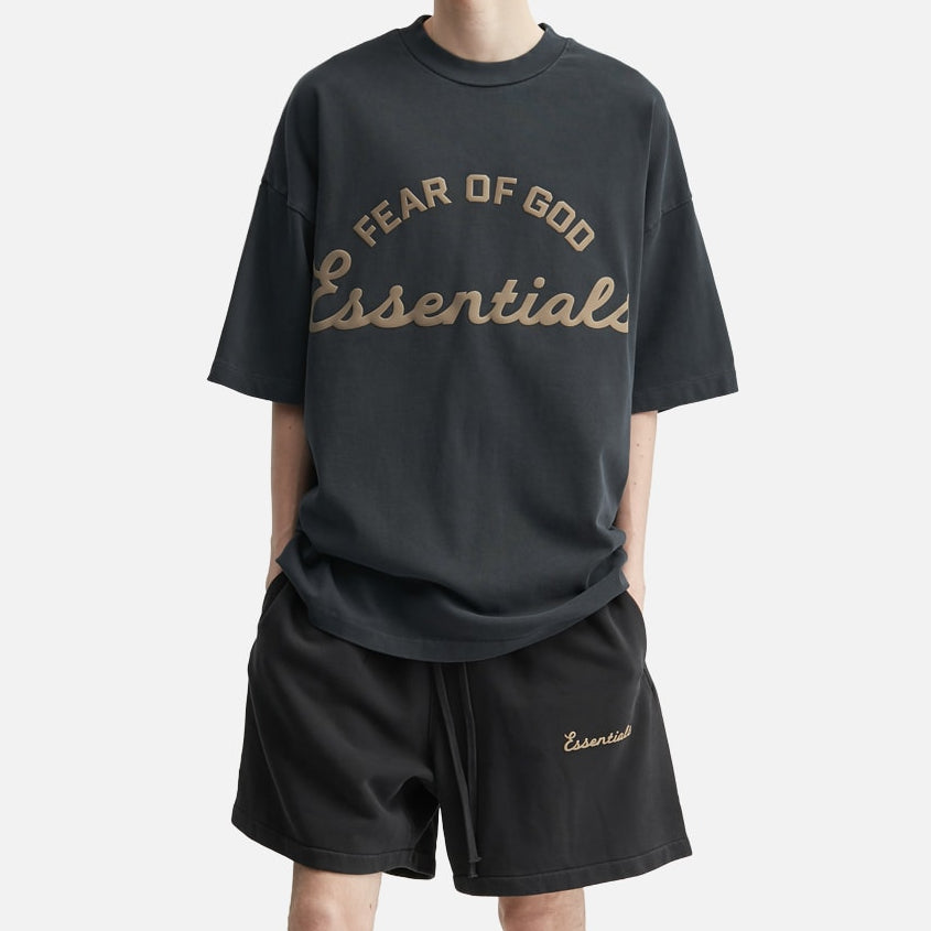 Fear of God Essentials Training 90s Shorts in faded black polyester fabric, featuring a relaxed fit and branded logo details.