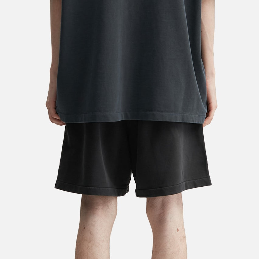 Fear of God Essentials Training 90s Shorts in faded black, displayed on a hanger, showcasing their relaxed fit and casual style.