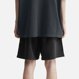 Fear of God Essentials Training 90s Shorts in faded black, displayed on a hanger, showcasing their relaxed fit and casual style.