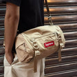 Tan Supreme box logo utility bag with adjustable strap, multiple compartments, and bold branding on durable fabric.