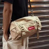 Tan Supreme box logo utility bag with adjustable strap, multiple compartments, and bold branding on durable fabric.