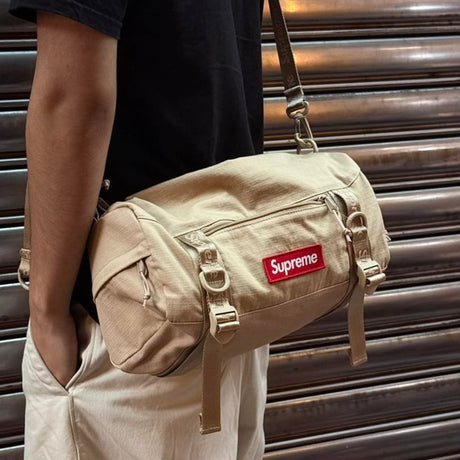 Tan Supreme box logo utility bag with adjustable strap, multiple compartments, and bold branding on durable fabric.