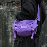 Supreme purple box logo utility bag with adjustable strap and zippered compartments, designed for versatile everyday use.