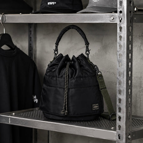Black Porter Yoshida Japan Tanker 2-Way Tool Bag with multiple compartments and sturdy handles, designed for versatile storage.