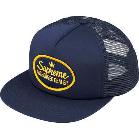 Navy Supreme mesh trucker cap with structured crown and curved brim, featuring the brand's logo patch on the front.