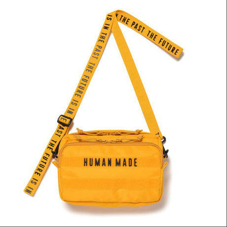 Yellow Human Made military sling bag with adjustable strap and multiple compartments, designed for casual and functional wear.