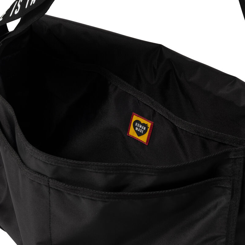 Black Human Made shoulder bag with adjustable strap and logo detail, made from durable materials.