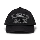 Black nylon 6-panel cap by HUMAN MADE with embroidered logo, showcasing casual headwear style and adjustable strap.