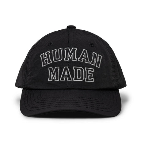 Black nylon 6-panel cap by HUMAN MADE with embroidered logo, showcasing casual headwear style and adjustable strap.
