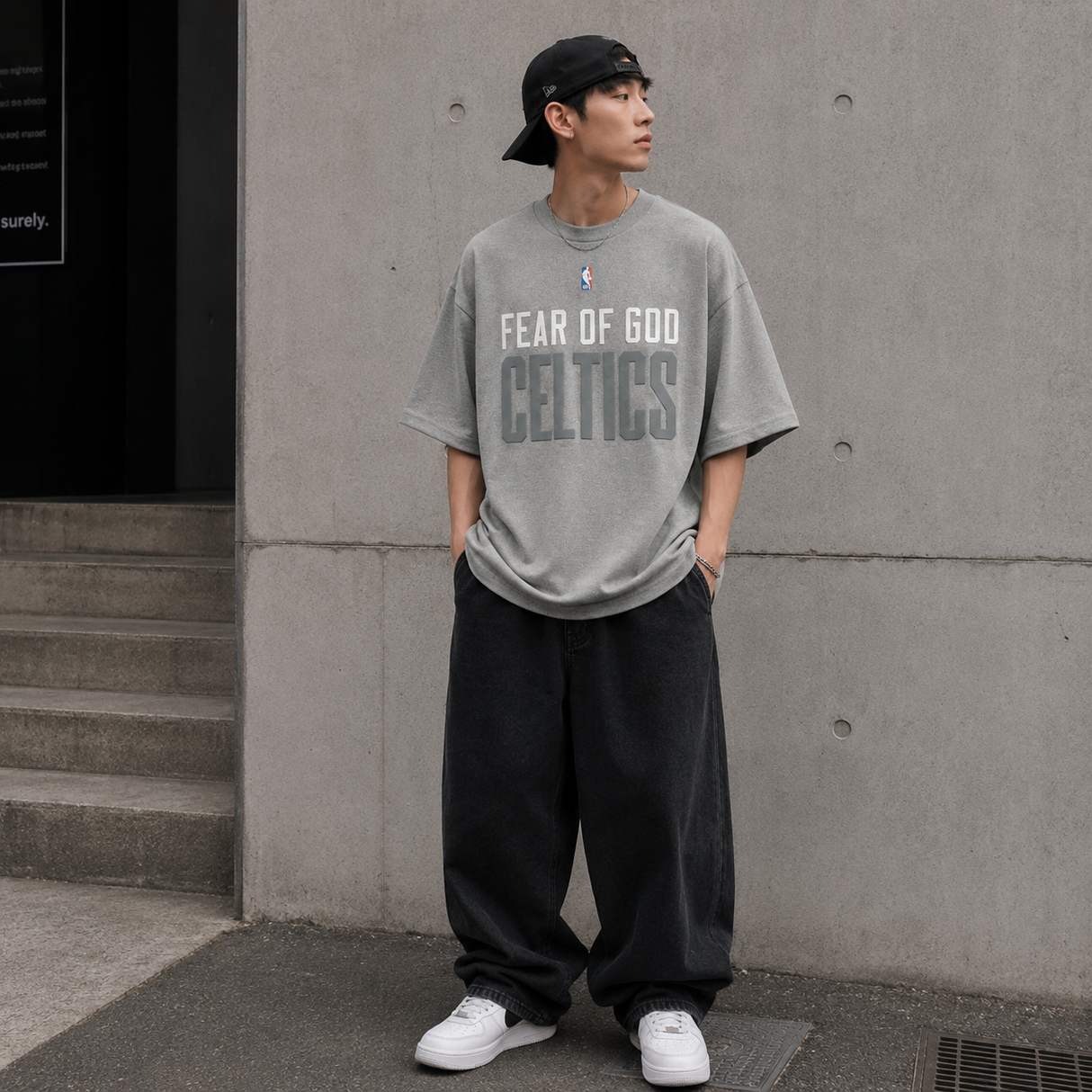 Fear of God Essentials X Celtics NBA 90s heavyweight tee in concrete, featuring the branded NBA and Celtics graphics on a casual apparel shirt.
