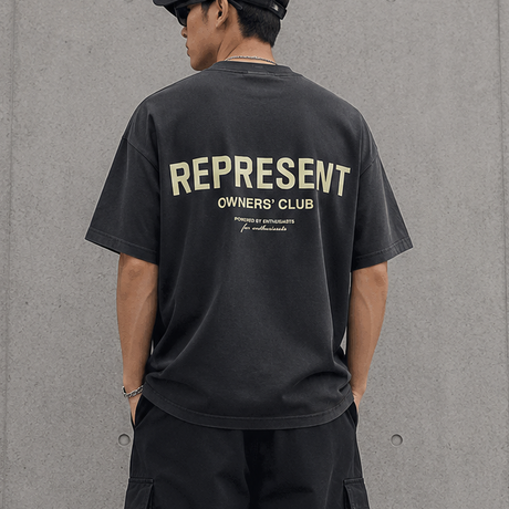 Represent Owners Club Logo Tee in aged black featuring a prominent club logo on the front.