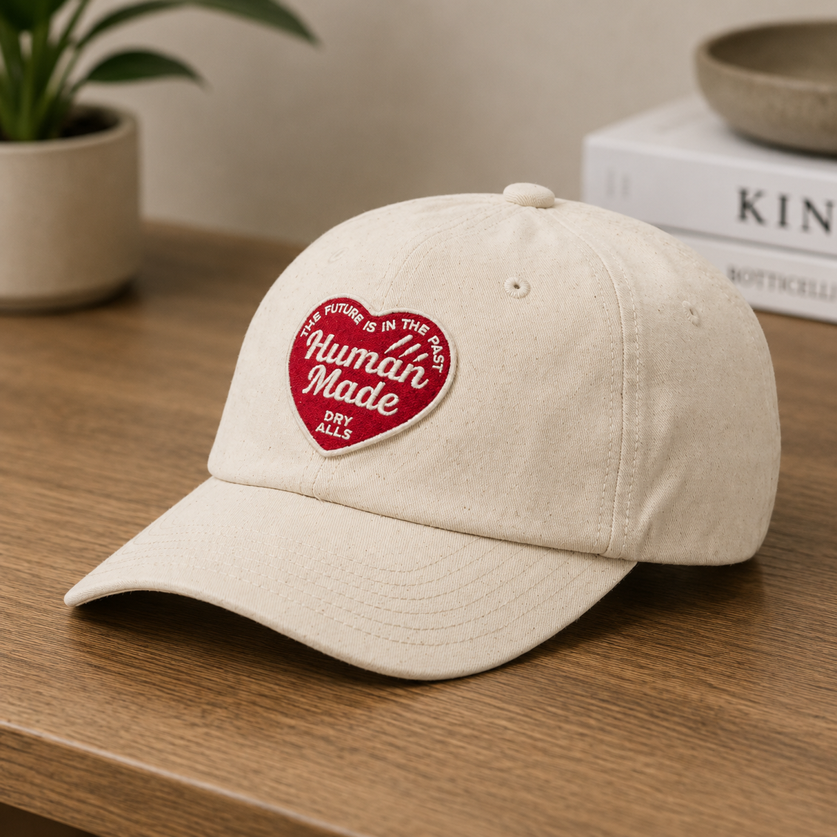 Human Made khaki six-panel twill cap with heart logo, stylish headwear featuring adjustable strap and classic design.