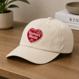 Human Made khaki six-panel twill cap with heart logo, stylish headwear featuring adjustable strap and classic design.