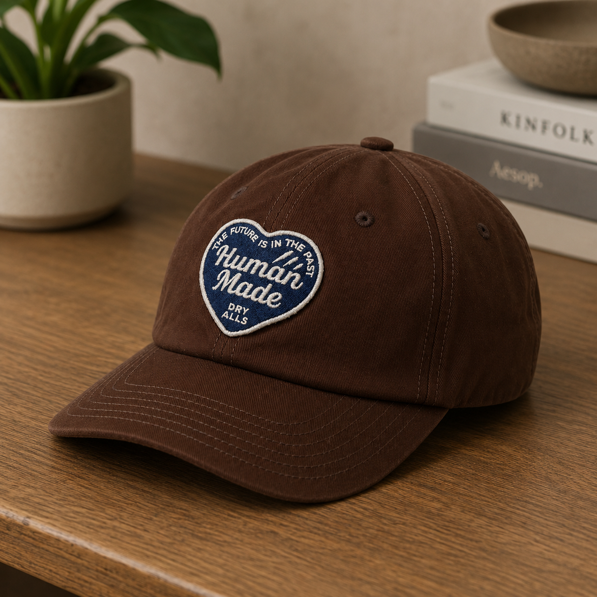 Human Made brown 6-panel twill cap with heart logo, casual headwear for streetwear and fashion styles.