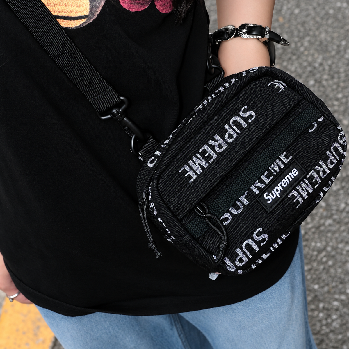 Supreme black reflective monogram logo mini shoulder bag with sleek design and adjustable strap for stylish carry.