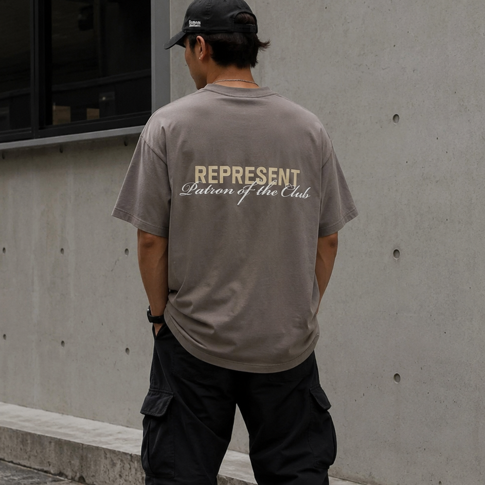 Olive green Represent Patron Of The Club Tee displayed flat, showing front view with logo design, casual streetwear style.