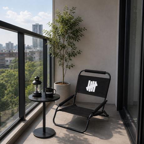 Black Undefeated foldable low chair, compact accessories with a sleek design, suitable for portable seating.