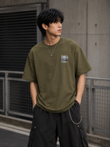 Olive green Undefeated foil logo t-shirt with photo graphic design, casual fit, short sleeves, and crew neck.