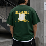 Forest green Undefeated Trademark Tee featuring the brand's logo on the front, displayed on a plain background.