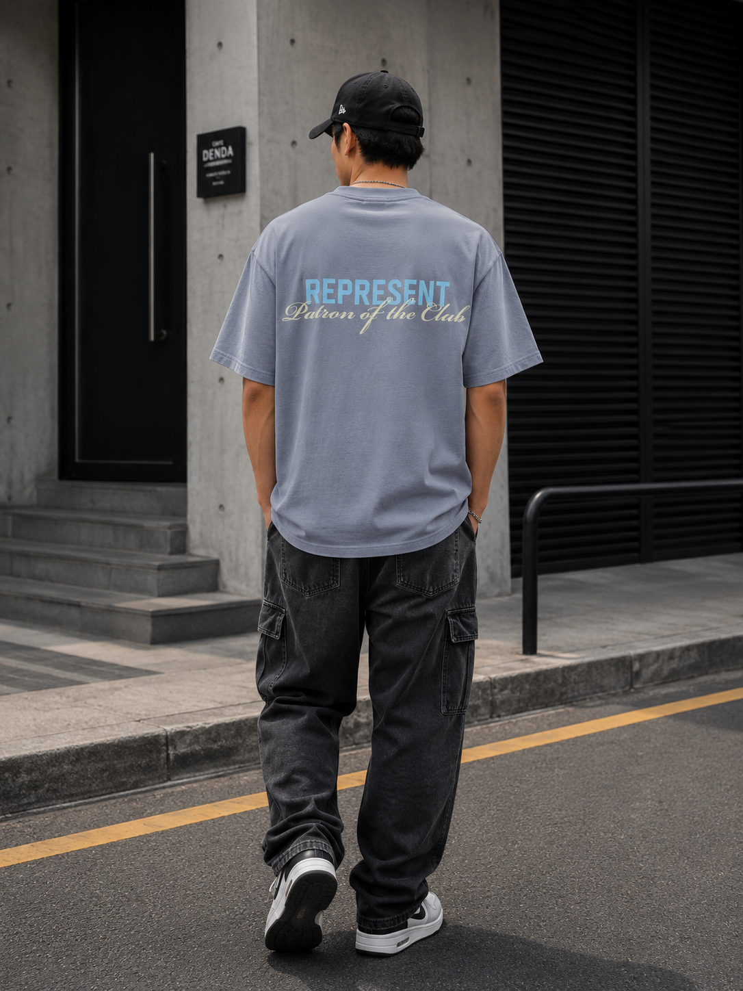 Gray Represent Patron Of The Club Tee displayed on a hanger, showcasing a casual apparel item with stylish branding details.