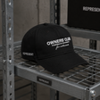 Black REPRESENT Owners Club Logo Snapback hat showing the front with the embroidered club logo and structured brim.